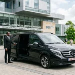 Van noir avec chauffeur professionnel devant un grand hôpital à Bruxelles