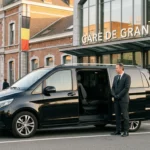 Mercedes Classe V noire avec chauffeur professionnel devant une gare