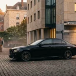 Berline noire premium stationnée devant un hôtel à Louvain-la-Neuve