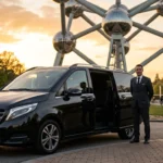Monospace noir avec chauffeur professionnel devant l'Atomium de Bruxelles