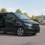 Taxi Mercedes Classe V noire avec chauffeur professionnel dans une rue de Wavre