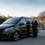 Minibus taxi noir avec chauffeur professionnel dans une rue de Wavre